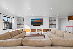 Living room featuring recessed lighting, wood finished floors, and built in shelves
