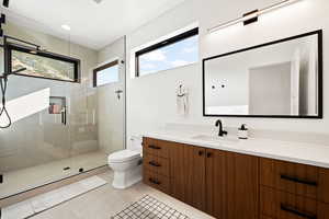 Bathroom featuring a stall shower, vanity, light tile patterned floors, and recessed lighting