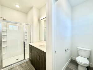 Bathroom featuring vanity, light wood finished floors, and a shower stall