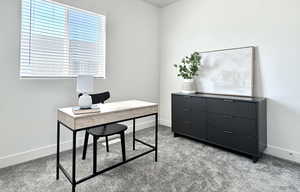 Carpeted office space with baseboards