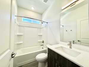 Bathroom with bathtub / shower combination, vanity, a textured ceiling, and dark wood finished floors