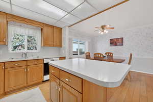 Kitchen featuring wainscoting, light countertops, light wood finished floors,  and a kitchen island