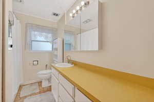 Bathroom with ornamental molding, a shower with shower curtain, vanity, and light tile patterned flooring