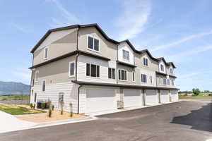 View of home's exterior with stucco siding, a residential view, an attached garage, and stone siding