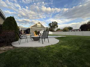 Fenced backyard featuring an outdoor fire pit and a patio area