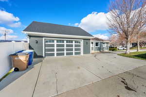 View of front of house with a shingled roof and concrete driveway