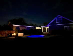 Back of house at twilight featuring a patio area, an outdoor fire pit, and an outdoor pool