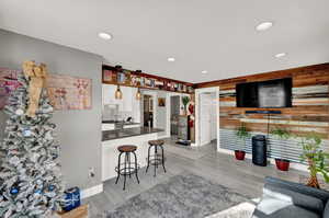 Kitchen featuring a breakfast bar area, dark countertops, white cabinetry, recessed lighting, and a peninsula