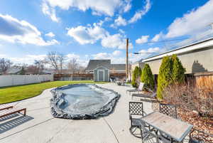 View of pool with a patio, a fenced backyard, a shed, and outdoor dining area