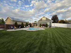 Rear view of house with a fenced backyard, a patio area, and an outdoor fire pit