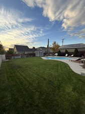 Fenced backyard with a patio area and a storage unit