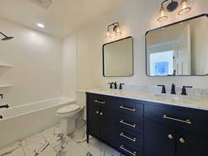 Bathroom with shower / washtub combination, double vanity, recessed lighting, and light marble finish flooring