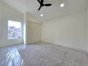 Unfurnished bedroom featuring lofted ceiling, a closet, ceiling fan, and recessed lighting