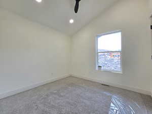 Carpeted empty room featuring lofted ceiling, recessed lighting, and ceiling fan