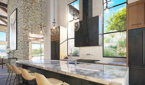 Kitchen with light stone countertops, paneled fridge, hanging light fixtures, and a high ceiling
