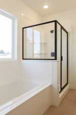 Bathroom featuring a shower stall and a bath