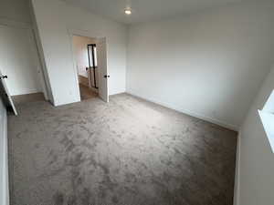 Unfurnished bedroom with carpet flooring and ensuite bath