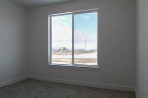 Carpeted empty room with baseboards