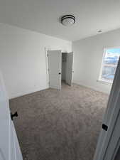 Unfurnished bedroom with carpet flooring and a closet