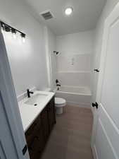 Full bath with vanity, shower / washtub combination, and dark wood-type flooring