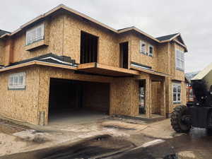 Unfinished property featuring an attached garage