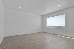 Empty room with light wood finished floors and recessed lighting