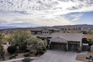 Mediterranean / spanish-style home featuring a mountain view, an attached garage, driveway, stucco siding, and a tile roof