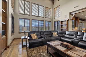 Living area featuring baseboards and a high ceiling