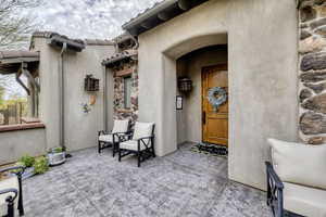 Entrance to property with stone siding and stucco siding