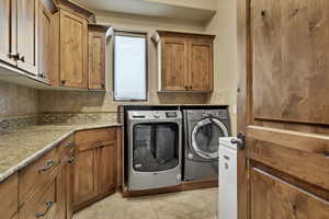 Laundry area featuring washing machine and clothes dryer and cabinet space