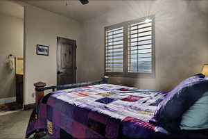 Carpeted bedroom with ceiling fan and baseboards