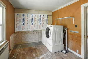 Washroom featuring radiator heating unit, hardwood / wood-style floors, and separate washer and dryer