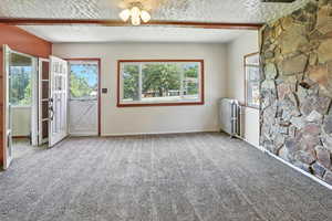 Carpeted spare room with radiator heating unit and a textured ceiling