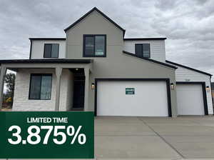 View of front facade with stone siding, concrete driveway, and a porch