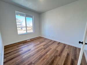 Empty room featuring wood finished floors and a textured ceiling