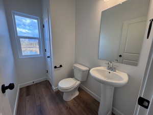 Bathroom featuring dark wood-type flooring and baseboards