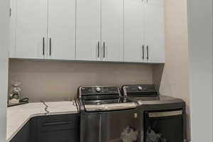Laundry area featuring cabinet space and washing machine and dryer