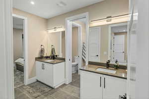 Bathroom featuring two vanities and recessed lighting