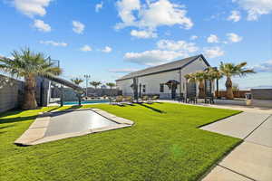 Fenced backyard featuring an in ground trampoline