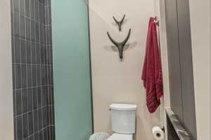 Full bath featuring tiled shower and radiator heating unit