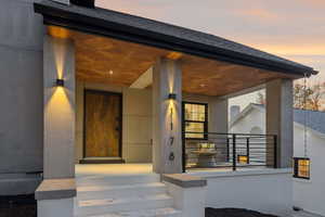 Property entrance with stucco siding and a porch