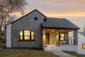 Contemporary home featuring roof with shingles, a porch, and a lawn