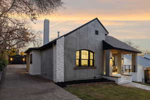 Modern home with an outbuilding, a front yard, a garage, and a porch