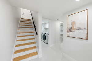 Stairs featuring washing machine and clothes dryer and tile patterned flooring