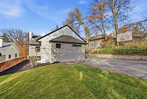 Rear view of house featuring roof with shingles and a chimney