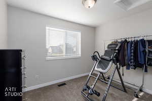 Exercise room with carpet floors and attic access
