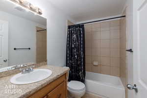 Bathroom with shower / bathtub combination with curtain and vanity