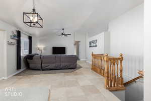 Living room with lofted ceiling, a chandelier, and ceiling fan