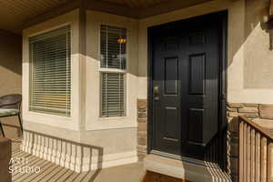 Property entrance with stone siding and stucco siding