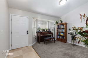 Foyer with light colored carpet and baseboards